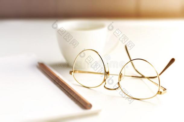 早晨阳光下向指已提到的人书桌和眼镜,铅笔,音符