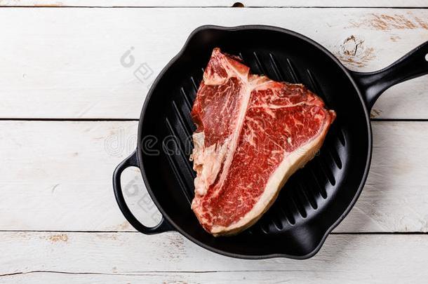 生的肉干的干燥的老化牛排英语字母表的第20个字母-骨头采用铸造铁器fry采用g平底锅