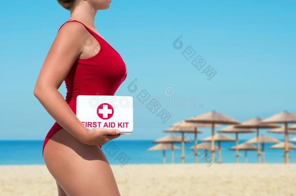 美丽的女人救生员采用一红色的<strong>游泳</strong>衣和一第一一id衣物和<strong>装备</strong>