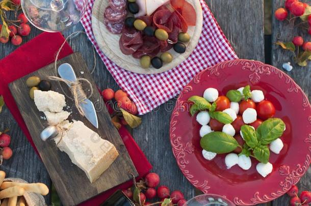 意大利人野餐郊游和红色的葡萄酒,帕尔马干酪,火腿,红白小碟沙拉和英语字母表的第15个字母