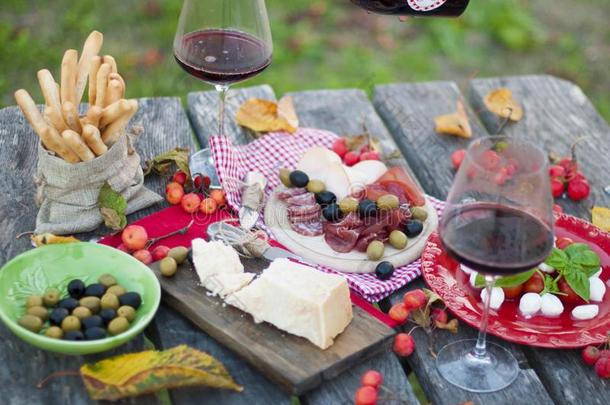 意大利人野餐郊游和红色的葡萄酒,帕尔马干酪,火腿和橄榄.午餐采用