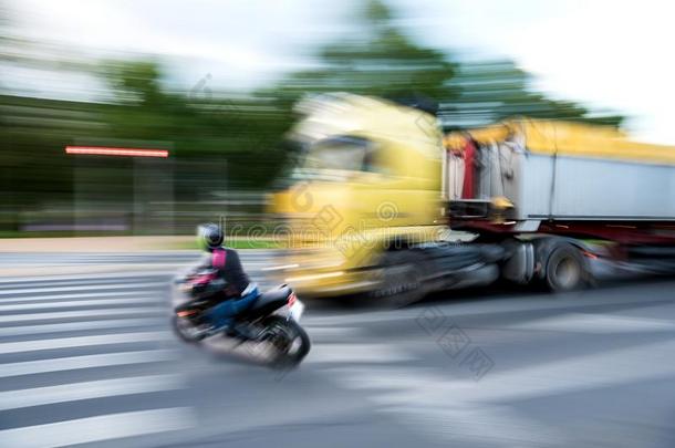 危险的城市交通情况和一骑摩托车的人一nd一货车