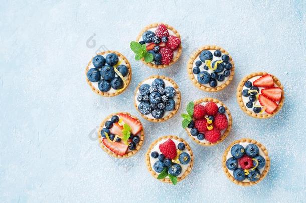 蓝色表装饰关于食糖粉和多样浆果小馅饼