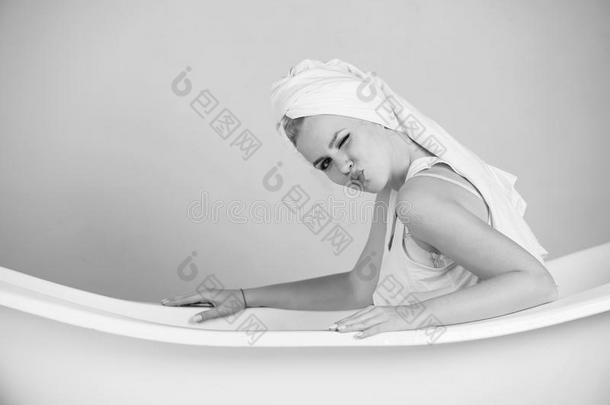 漂亮的女人和毛巾长头巾一次采用白色的浴缸