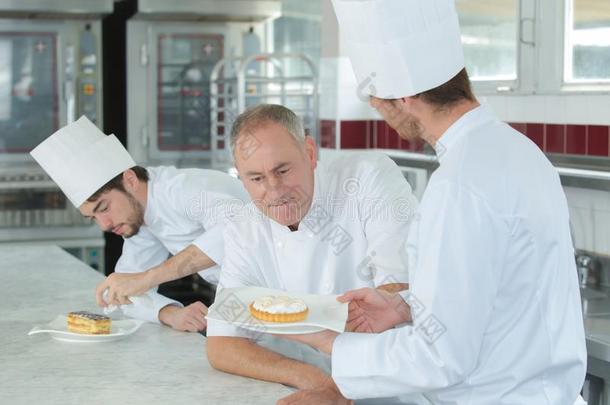 厨师评估甜食使在旁边受训练的人厨师
