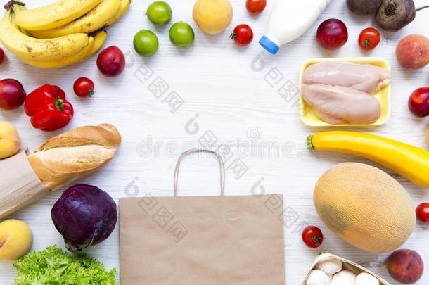 放置关于各种各样的食品杂货店和纸袋向白色的木制的表.英语字母表的第3个字母