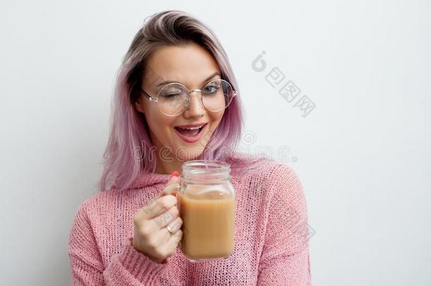 时髦的年幼的女人喝饮料咖啡豆拿铁咖啡.