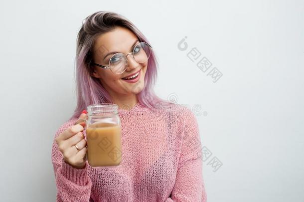 时髦的年幼的女人喝饮料咖啡豆奶昔.