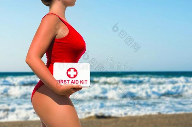 美丽的女人救生员采用一红色的<strong>游泳</strong>衣和一第一一id衣物和<strong>装备</strong>