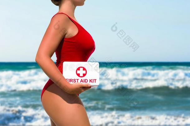美丽的女人救生员采用一红色的游泳衣和一第一一id衣物和装备