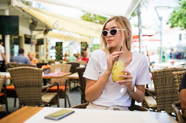 年幼的女人喝饮料鸡尾酒柠檬汽水采用咖啡馆