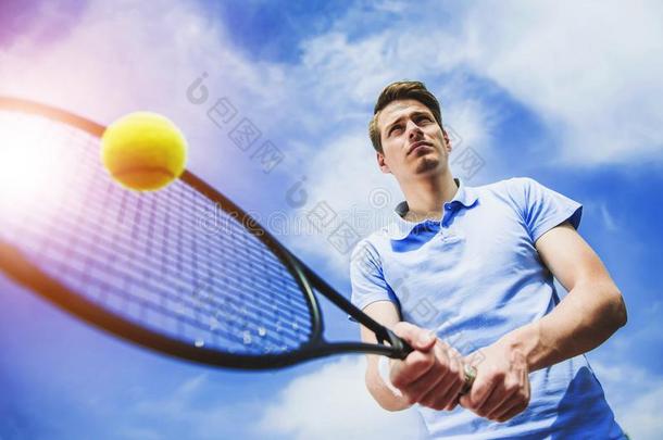 幸福的网球演员准备好的向打球和球拍