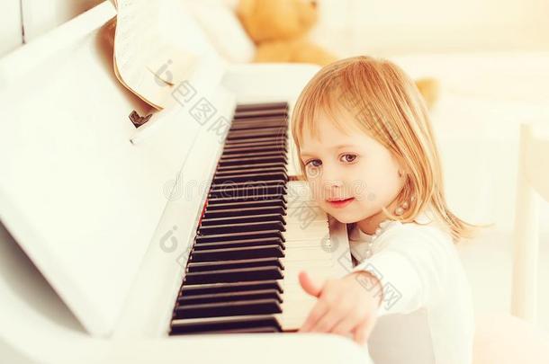 漂亮的小的女孩演奏钢琴在一音乐学校.Pre学校children儿童