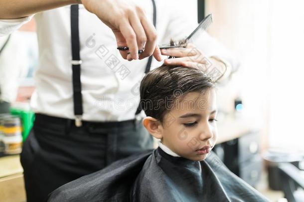 男孩所有理发和梳子和剪刀在理发师商店