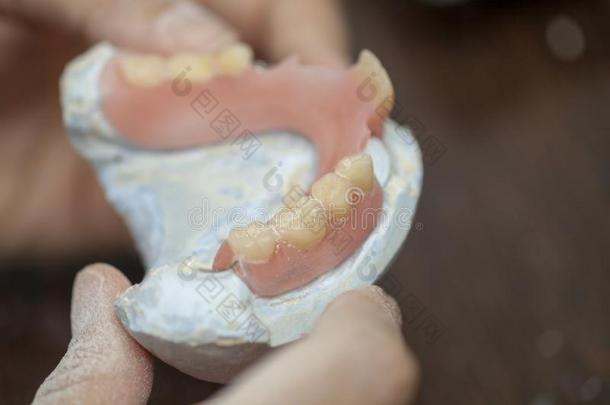 <strong>牙齿</strong>的技术人员检查他的使工作关于假牙假肢采用<strong>牙齿</strong>的