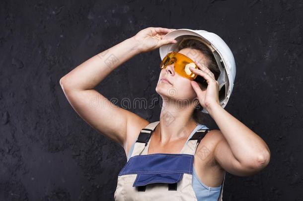 女人建设者工人采用制服和白色的头盔和保护的