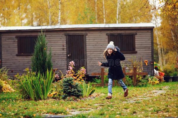 幸福的小孩女孩跑步采用晚的秋花园