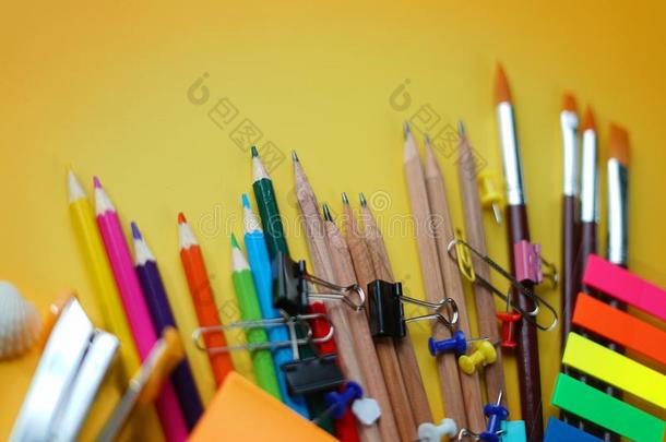 颜色铅笔,刷子和学校不动的向黄色的背景