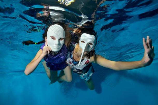 在水中的剧场.两个不常见的女儿游泳和比赛在水中的我
