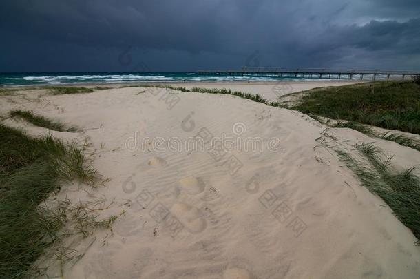 长满草的海滩-面沙沙丘和黑暗的暴风雨云向指已提到的人horizon地平线