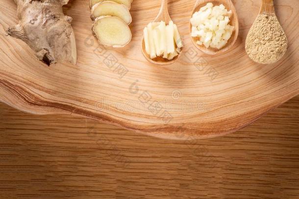 姜根,姜切成片和姜粉向木制的背景