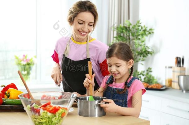 年幼的保姆和漂亮的小的女孩烹饪术