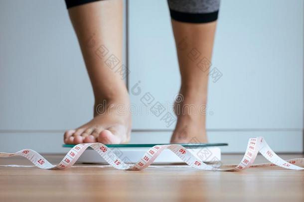 女人脚步进向称的重量刻度和带子测量采用先知