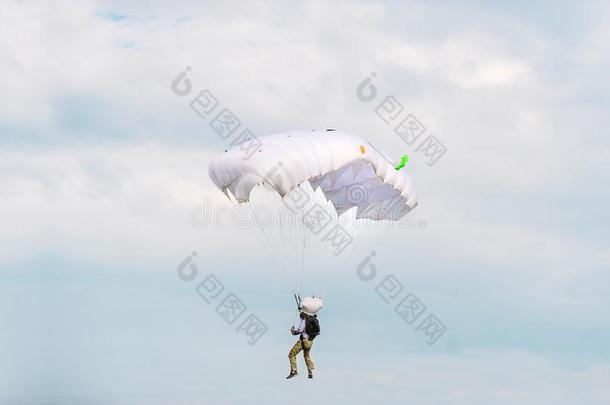做空中造<strong>型动</strong>作的跳伞运<strong>动</strong>员和白色的降落伞向指已提到的人天背景