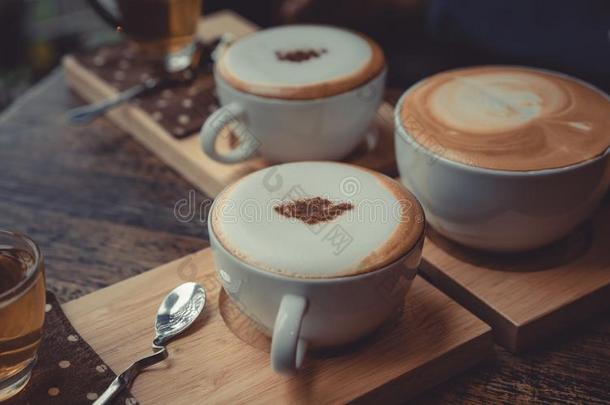 热的拿铁咖啡咖啡豆向木制的茶<strong>杯托</strong>