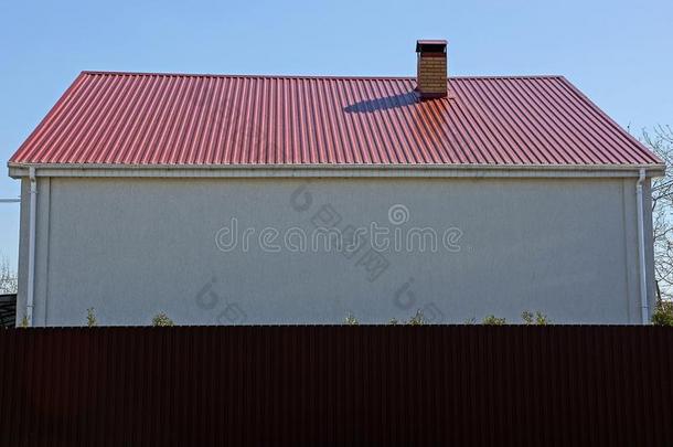 白色的<strong>墙</strong>关于一房屋和一<strong>红色</strong>的ro关于在的后面一棕色的<strong>栅栏</strong>