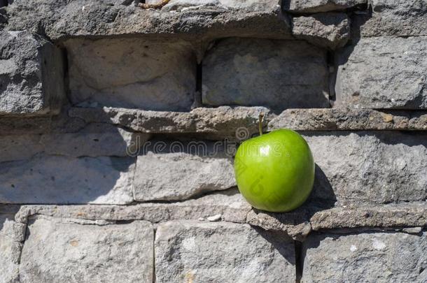 苹果是（be的三单形式坐落的采用指已提到的人老的砖灰色墙
