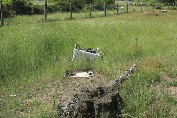 一老的,破碎的洗涤机器,无忧无虑地投离开向草地