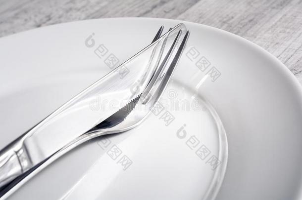 放置关于十字的<strong>不锈</strong>的钢餐叉和刀向一正餐盘子