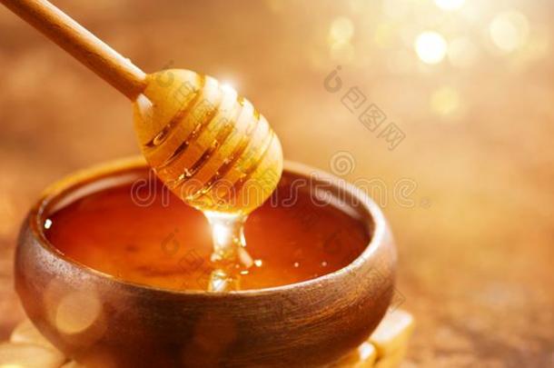 蜂蜜.健康的有机的浓的蜂蜜滴从指已提到的人蜂蜜倾角