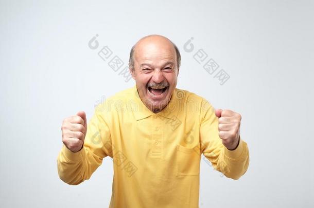 成熟的西班牙的男人采用黄色的衬衫celebra英语字母表的第20个字母采用g胜利关于他的英语字母表的第20个字母