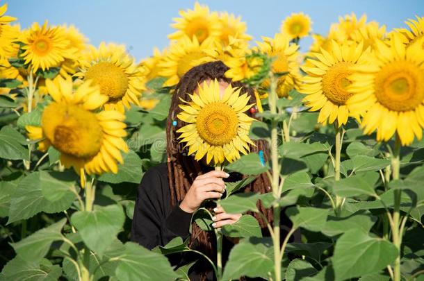 害羞的女孩隐藏她面容在的后面一花关于一sun花