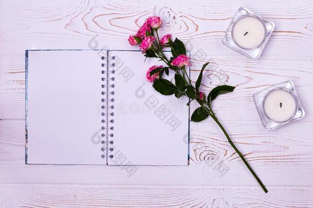 空白的笔记簿,花,蜡烛向一白色的b一ckground从一bove