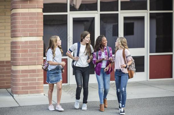 青少年女儿离开学校讲话和步行同时