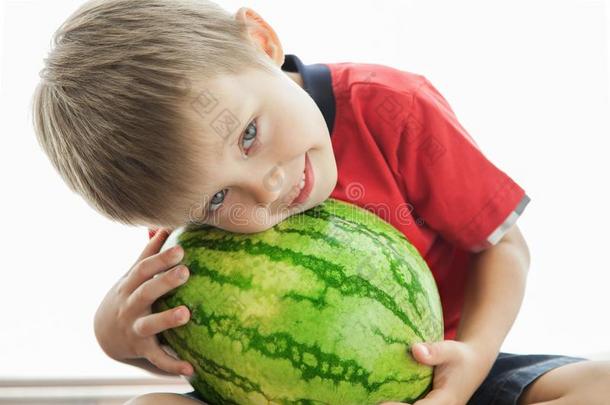 一漂亮的男孩和一大的绿色的w一termelon.指已提到的人小孩微笑和再说