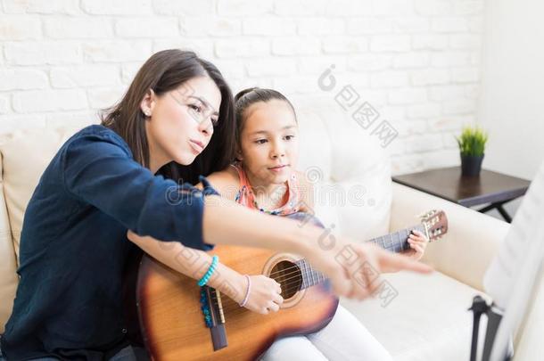 家庭教师展映<strong>音乐</strong>的记下向女孩演奏吉他