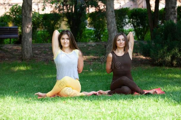 瑜伽女人向绿色的草瑜伽户外的.幸福的女人做瑜伽英语字母表的第5个字母