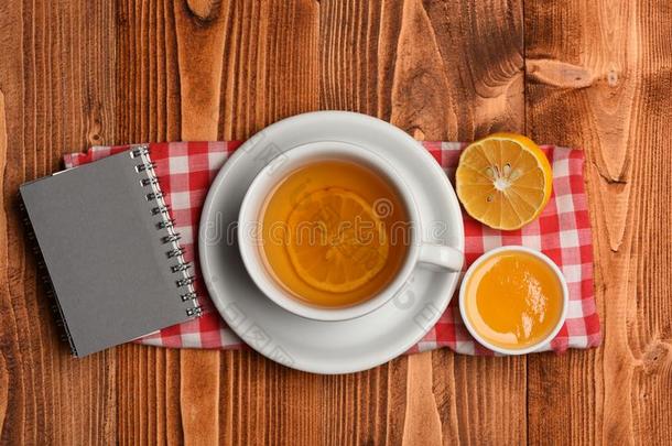 茶水杯子和蜂蜜和小的笔记簿,顶看法