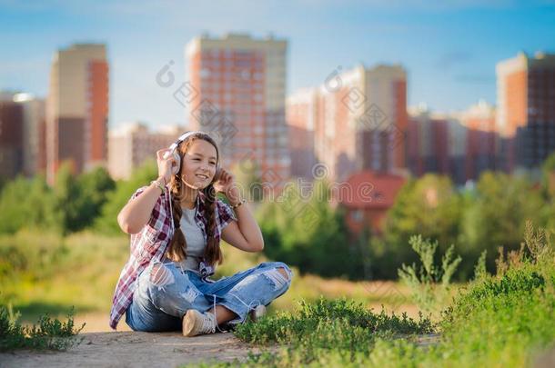 年幼的女孩收听的向音乐向headph向es,都市的大街方式,