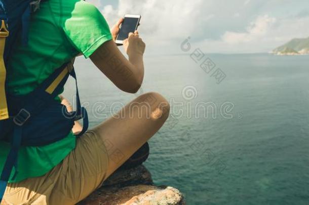 女人远足者使用智能手机向徒步旅行旅行