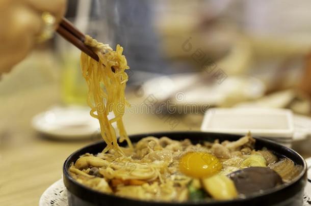 手和筷子吃日本人乌冬面面条和鸡蛋.