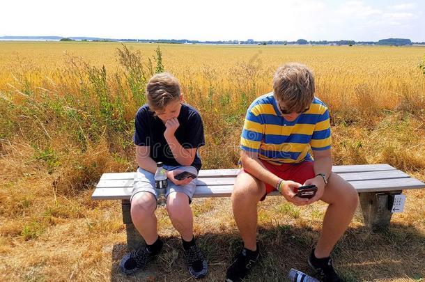 两个男孩采用自然已占用的在旁边他们的智能手机