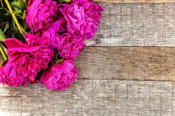 花的框架和粉红色的牡丹向木制的背景