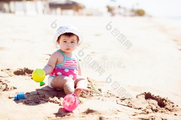 美丽的婴儿令人轻松的在指已提到的人海滩