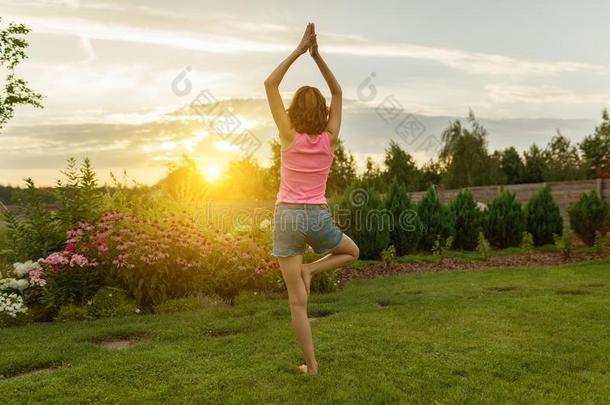 年幼的女孩开业的瑜伽,深思向一夏日落b一ckgr