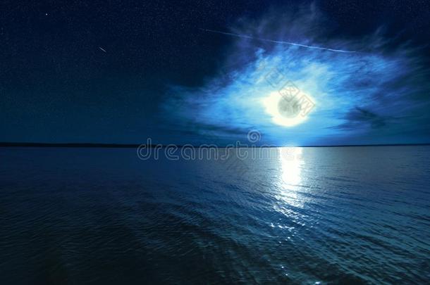 美丽的魔法蓝色夜布满星星的天和云和满的月亮